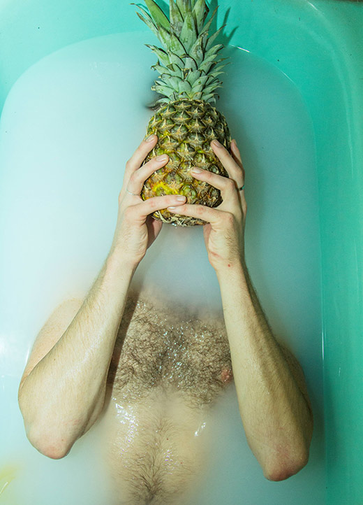 Join Life - Like a Virgin exhibition: man half submerged in water with pineapple